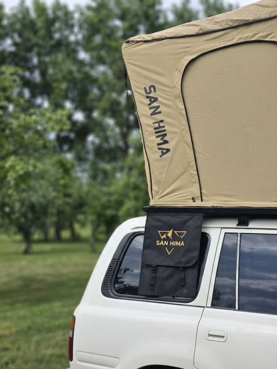 Close-up van de opengeklapte LCM Savannah daktent in zandkleur met SAN HIMA schoenenvak aan de Toyota Land Cruiser