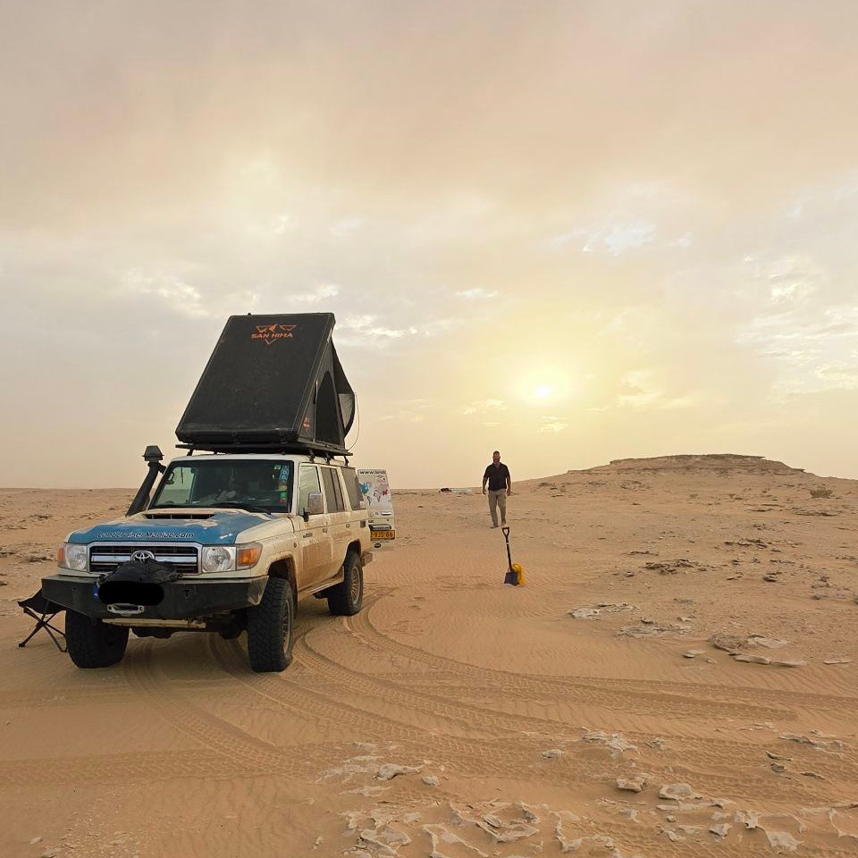 Toyota Land Cruiser with the LCM Offroad Dune hardshell rooftop tent open in the desert at sunset